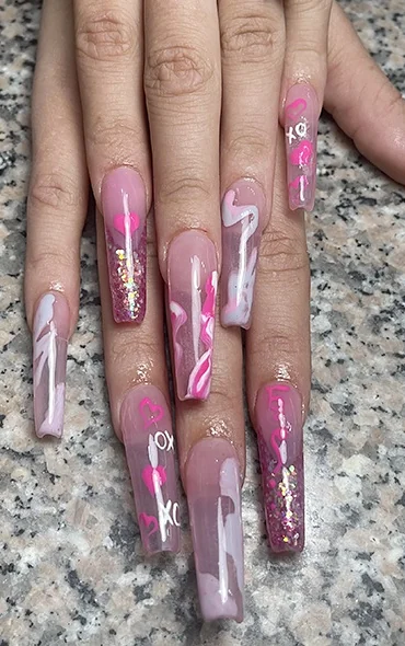Extra-long clear pink coffin nails with painted hearts, XO lettering and pink marbling